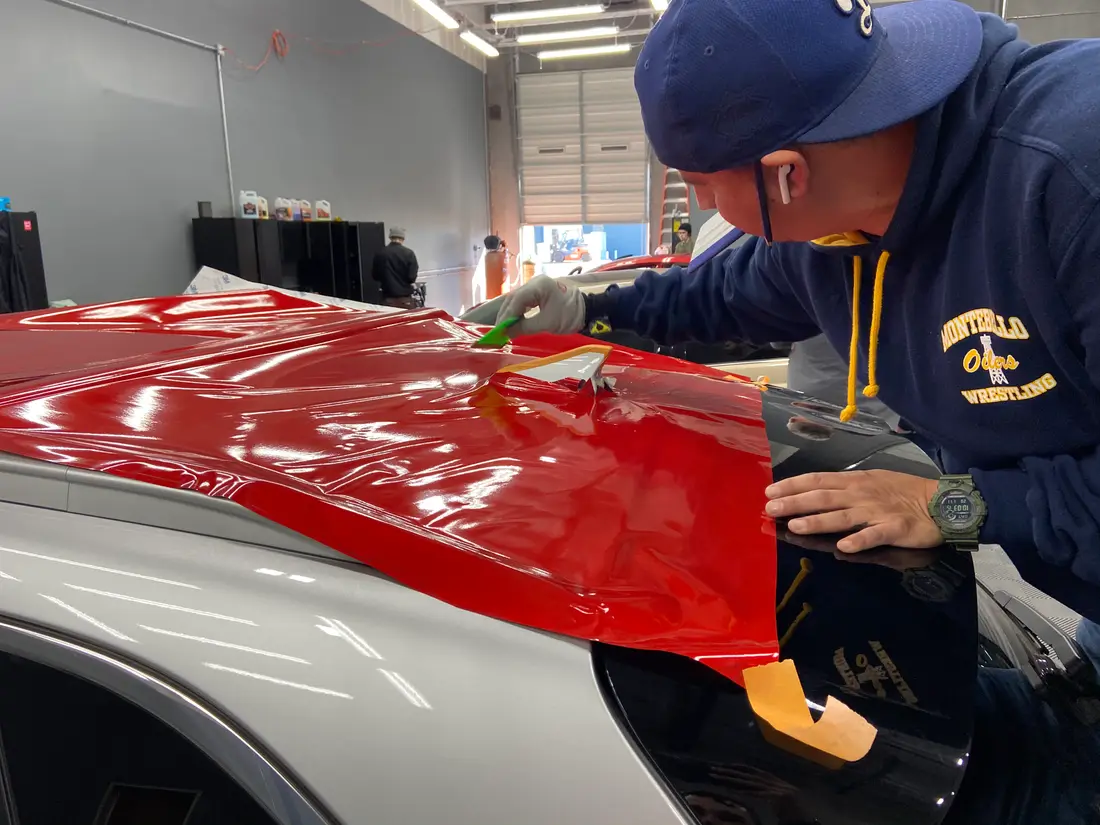XPEL Color red paint protection film applied over a factory hood